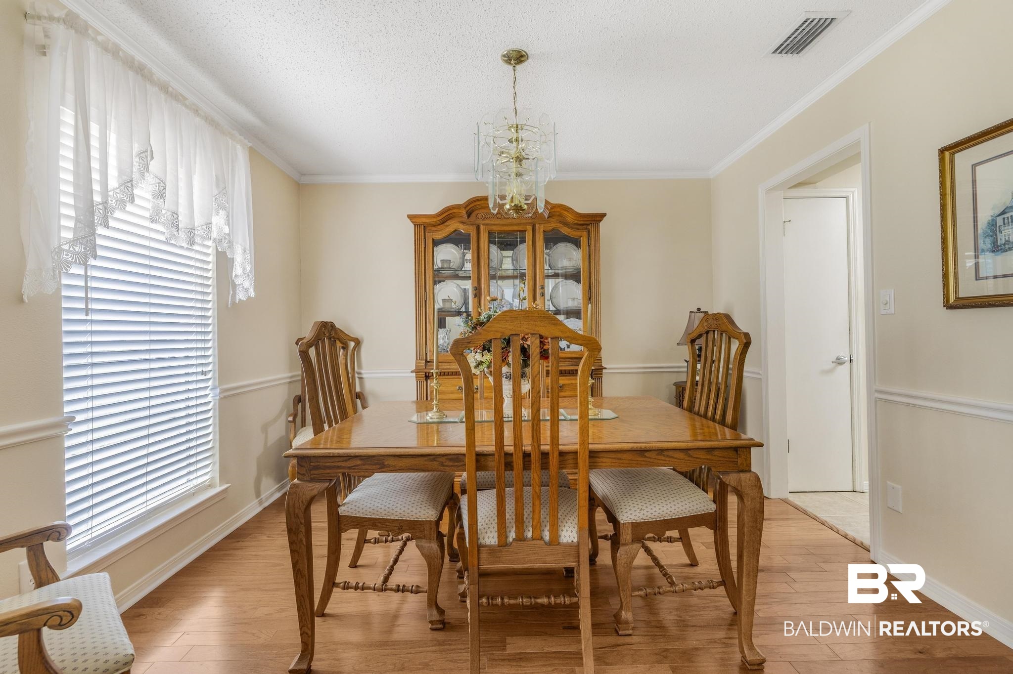 10207 Plantation Drive Daphne, AL 36526 - Photo 47 of 48 Dining space with a chandelier, light wood-style flooring, and ornamental molding
