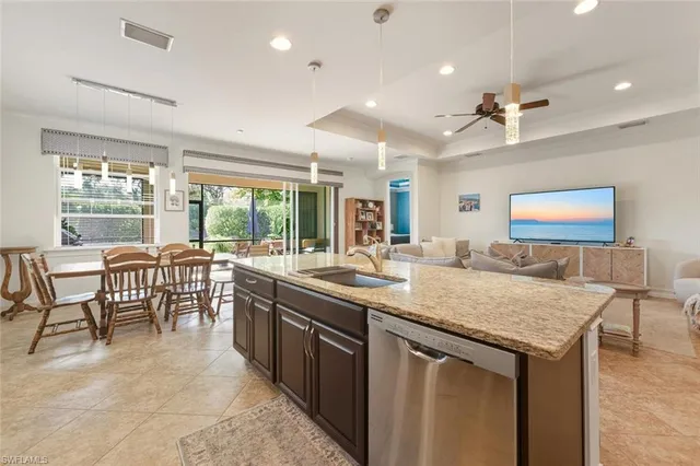 a kitchen with a stove a sink and a dining table with garden view