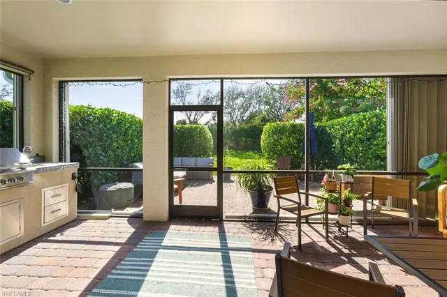 a living room with a floor to ceiling window and wooden floor