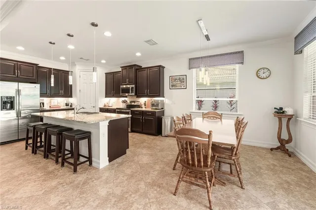 a kitchen with kitchen island a dining table and chairs