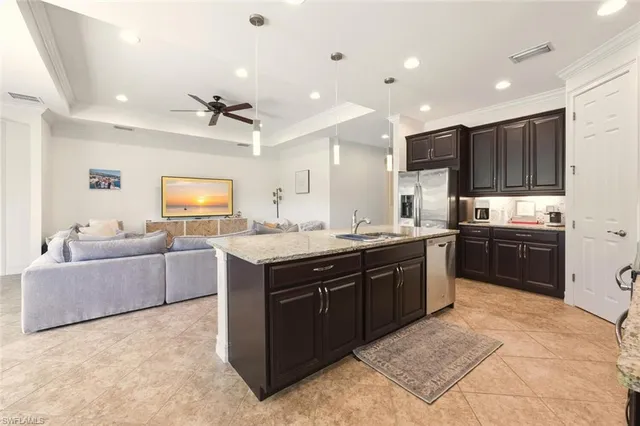 a kitchen with kitchen island sink cabinets and refrigerator