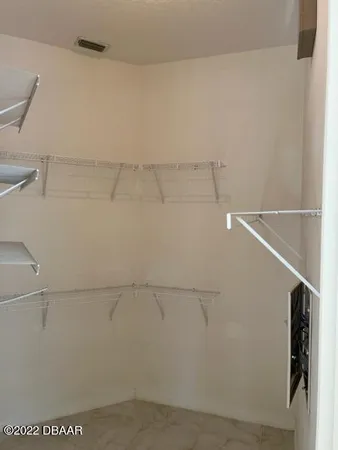 a view of an empty room with a chandelier fan