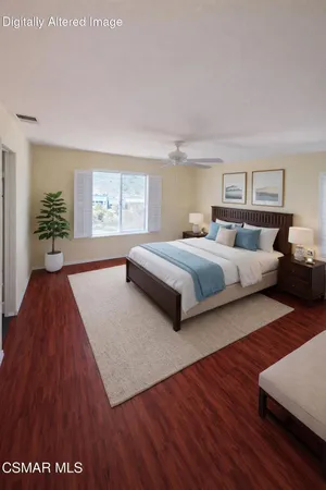 a spacious bedroom with two beds and a wooden floor