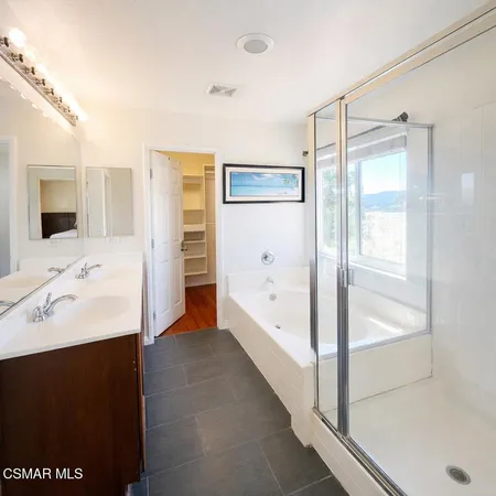 a bathroom with a tub sink shower and mirror