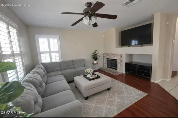 a living room with furniture a flat screen tv and a fireplace