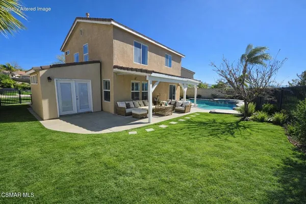 a view of a house with a yard and sitting area