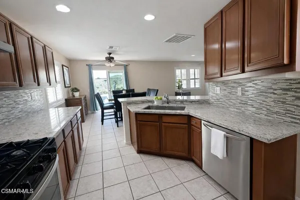 a kitchen with stainless steel appliances granite countertop a sink stove and cabinets