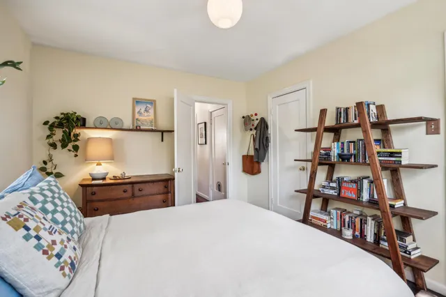 a bedroom with a bed and a book shelf
