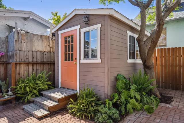 a backyard of a house with plants and outdoor seating