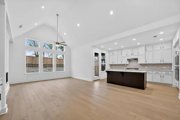 a large kitchen with stainless steel appliances kitchen island a large counter top and a wooden floors