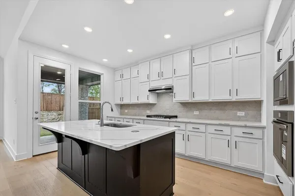 a kitchen with a sink window and cabinets