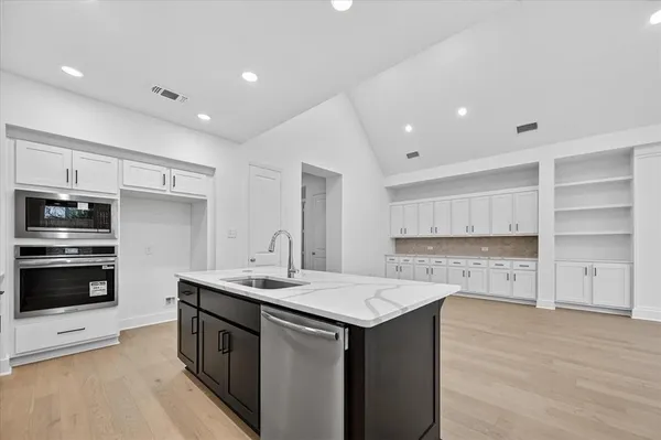a kitchen with a sink stainless steel appliances and white cabinets