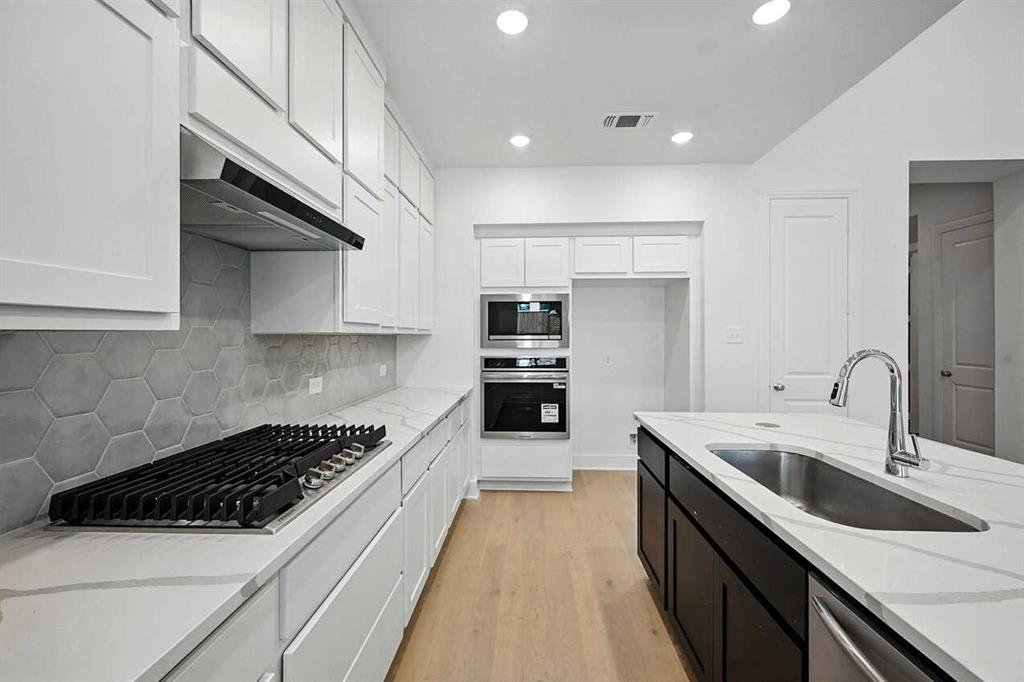 413 Heritage Rnch Trail Sherman, TX 75092 - Photo 3 of 30 a kitchen with stainless steel appliances a sink a stove and cabinets