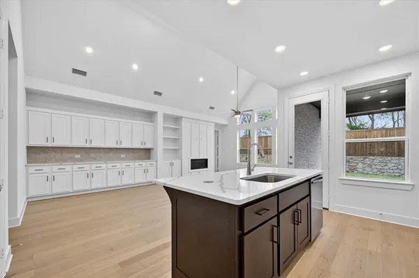 a kitchen with a sink window and cabinets