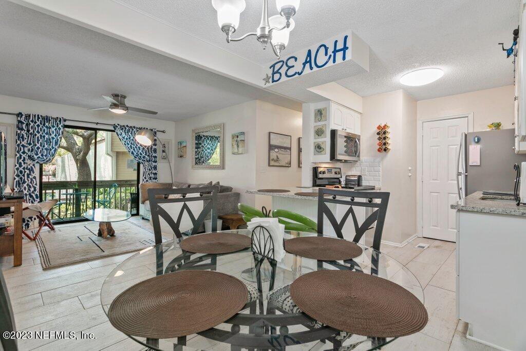 2694 Forest Ridge Drive, Unit 4A Fernandina Beach, FL 32034 - Photo 13 of 38 a view of a dining room with furniture a chandelier and wooden floor