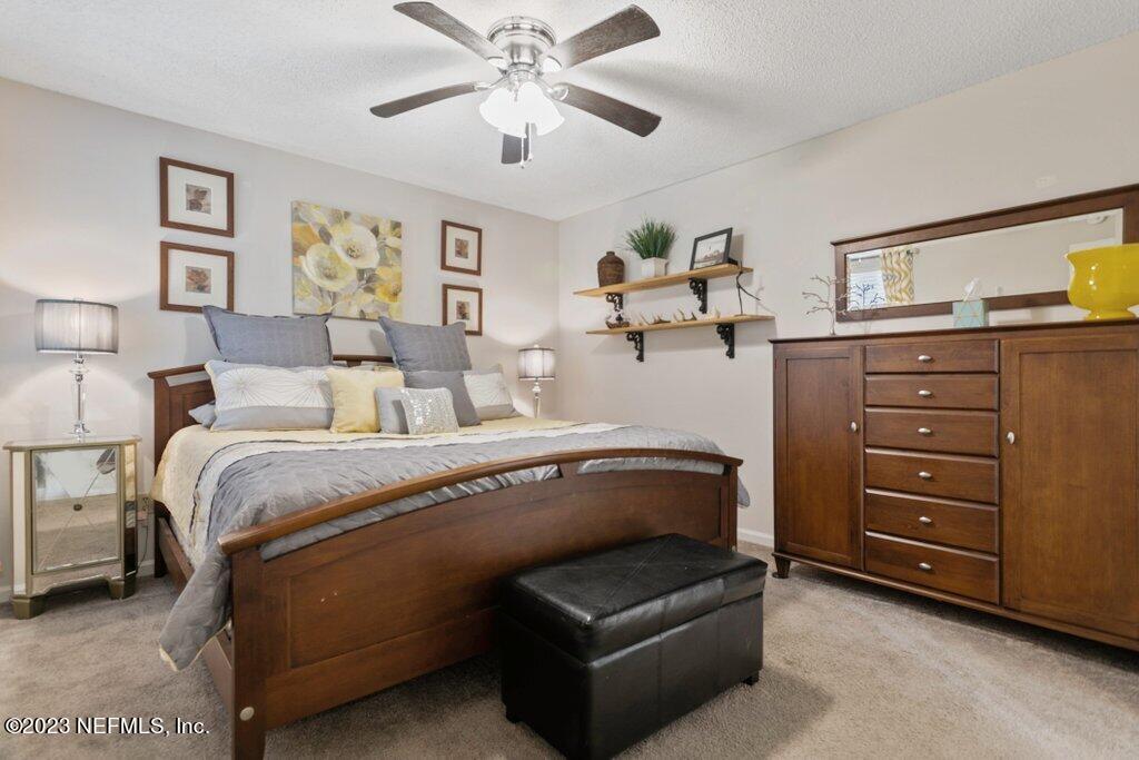 2694 Forest Ridge Drive, Unit 4A Fernandina Beach, FL 32034 - Photo 17 of 38 a bedroom with a bed and a chandelier
