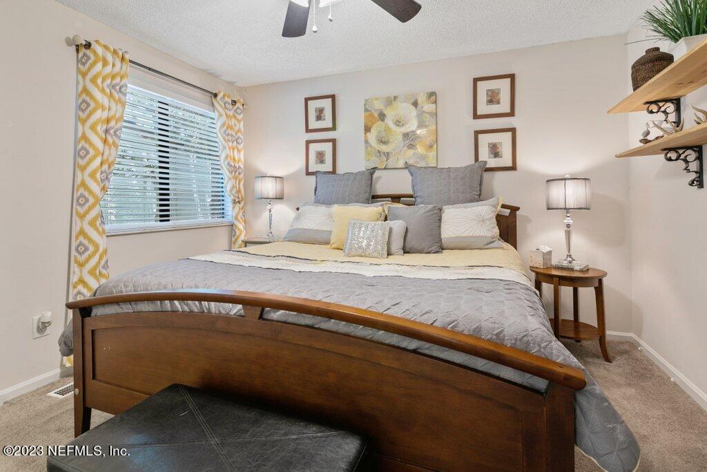 2694 Forest Ridge Drive, Unit 4A Fernandina Beach, FL 32034 - Photo 18 of 38 a spacious bedroom with a bed and painting on the wall