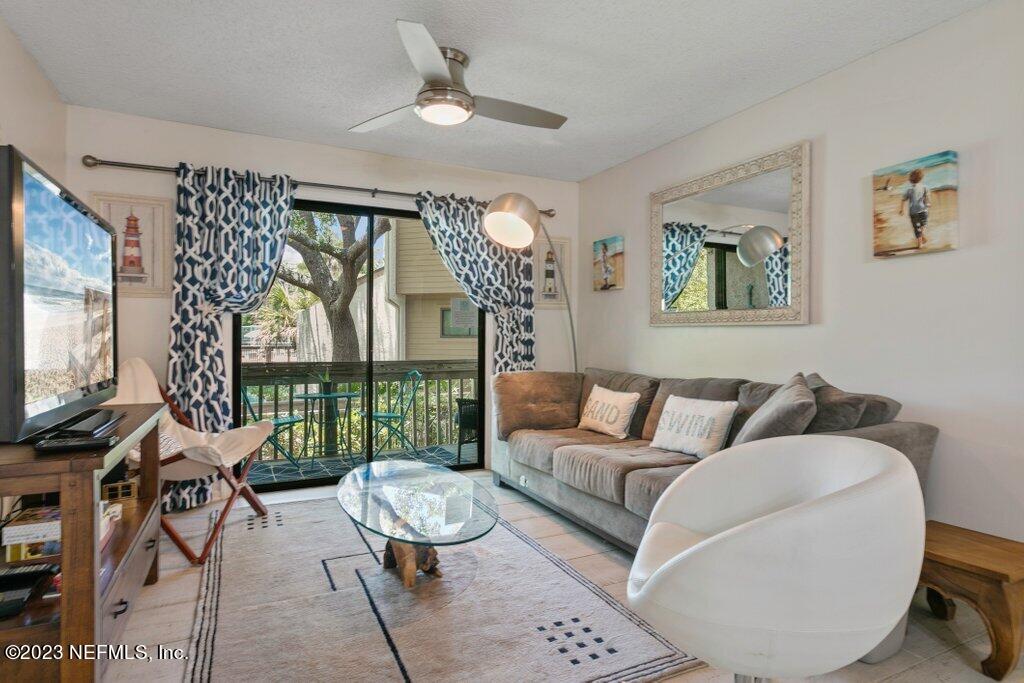 2694 Forest Ridge Drive, Unit 4A Fernandina Beach, FL 32034 - Photo 4 of 38 a living room with furniture a flat screen tv and a floor to ceiling window