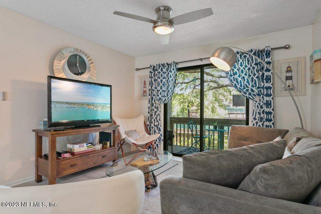 2694 Forest Ridge Drive, Unit 4A Fernandina Beach, FL 32034 - Photo 5 of 38 a living room with furniture a flat screen tv and a floor to ceiling window