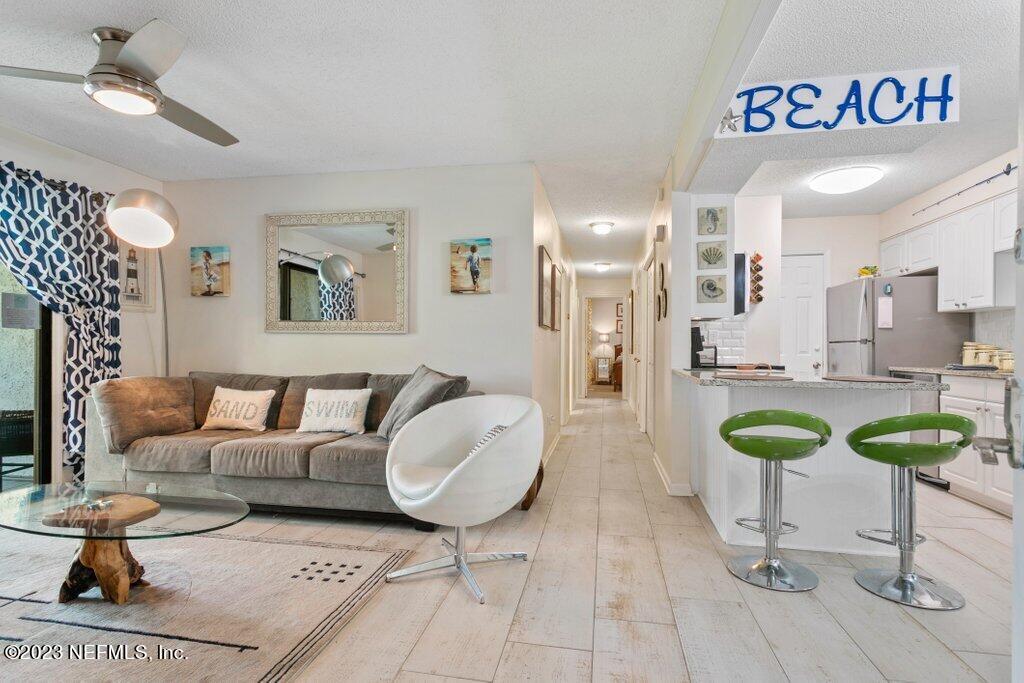 2694 Forest Ridge Drive, Unit 4A Fernandina Beach, FL 32034 - Photo 7 of 38 a living room with furniture a chandelier and a table