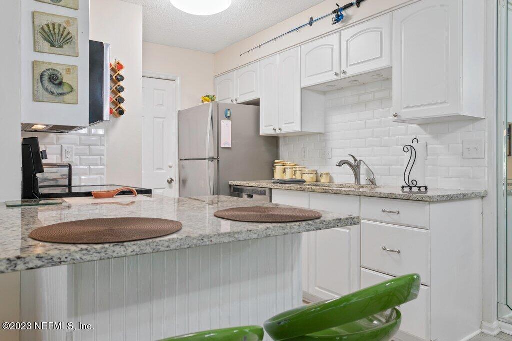 2694 Forest Ridge Drive, Unit 4A Fernandina Beach, FL 32034 - Photo 9 of 38 a kitchen with stainless steel appliances granite countertop a sink and a white cabinets
