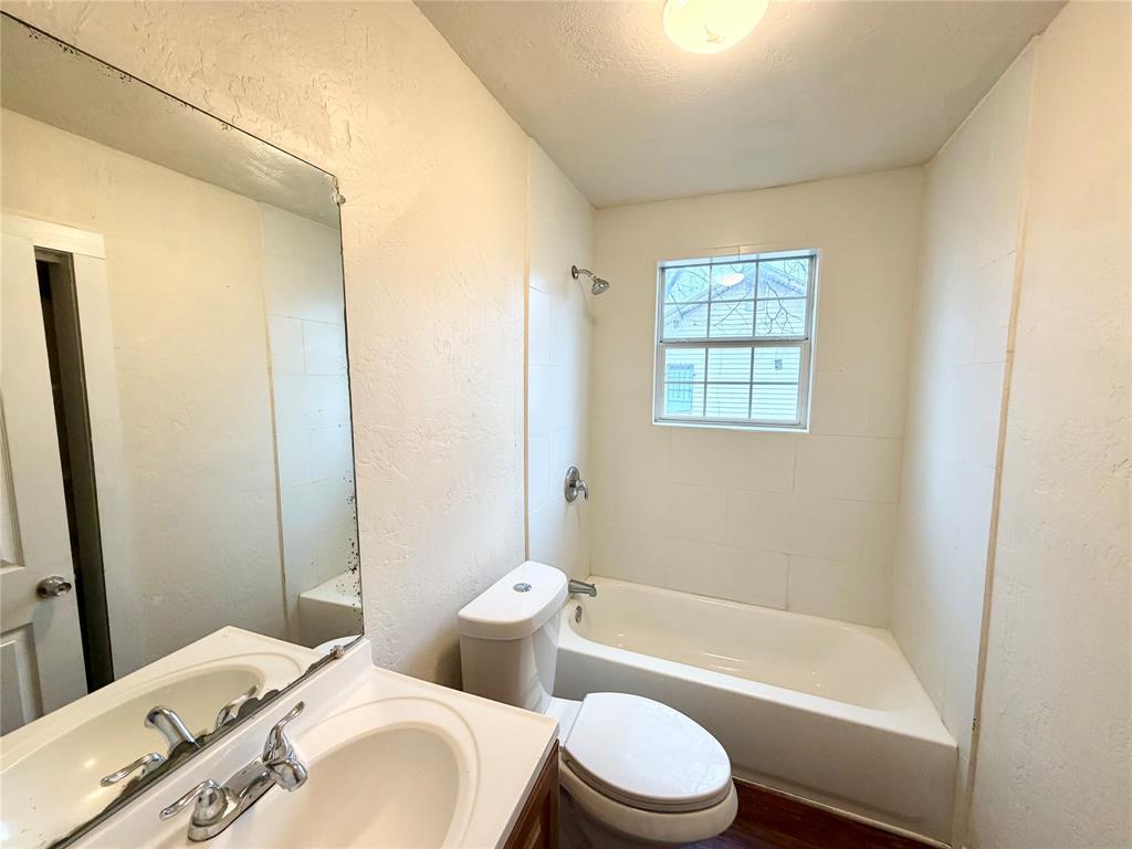 1140 Faulkner Lane Waco, TX 76704 - Photo 12 of 17 a bathroom with a granite countertop toilet a sink and a bathtub