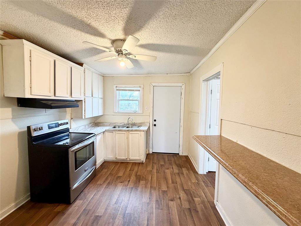 1140 Faulkner Lane Waco, TX 76704 - Photo 9 of 17 a kitchen with granite countertop wooden floors and white appliances