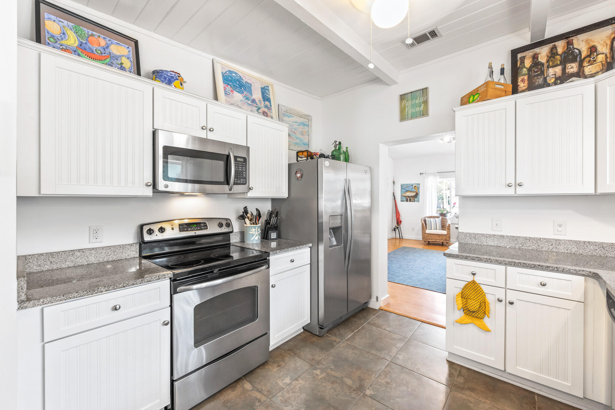 71 Sea Oates Road Santa Rosa Beach, FL 32459 - Photo 48 of 59 a kitchen with stainless steel appliances white cabinets a sink a stove a refrigerator with a dining table and chairs