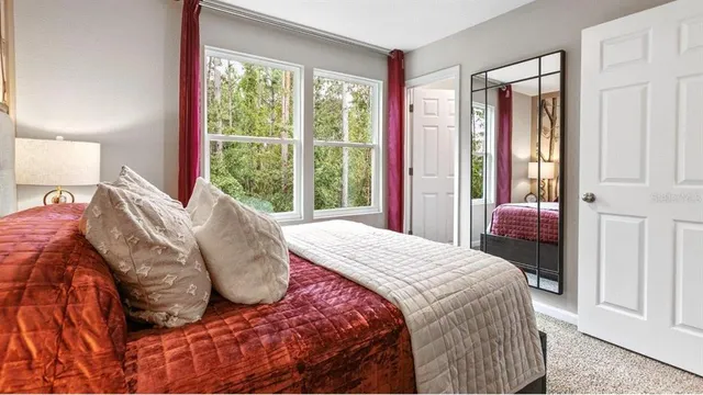 a bedroom with a bed and a large window