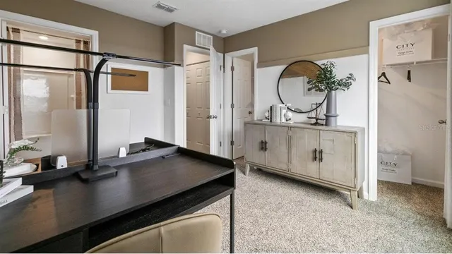 a room with a table chairs and a refrigerator