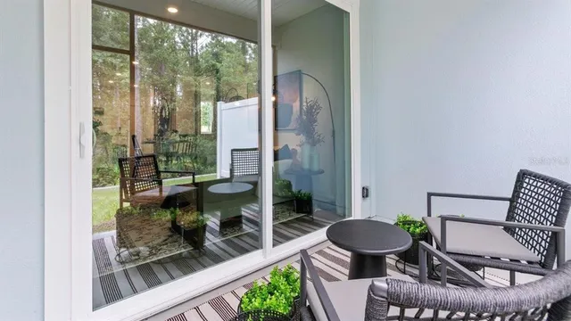a living room with furniture and a floor to ceiling window