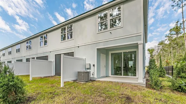 a view of a white house with a large windows and plants