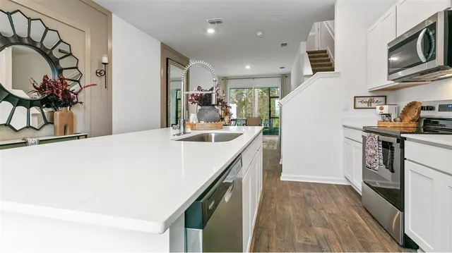 a kitchen with kitchen island a sink stove and cabinets