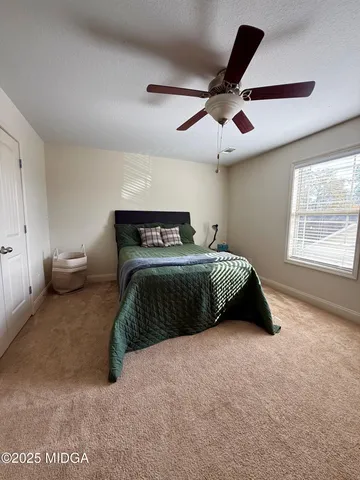 a bedroom with a bed and a ceiling fan