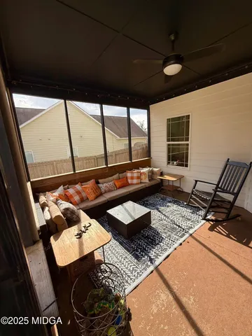 a living room with furniture and a floor to ceiling window