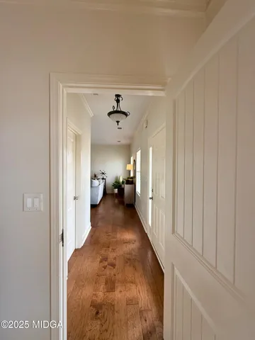 a view of a hallway with a livingroom and a chandelier