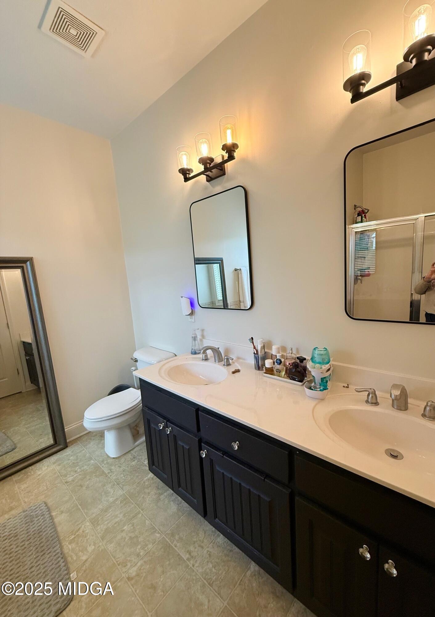149 Presidents Way Forsyth, GA 31029 - Photo 10 of 26 a bathroom with a double vanity sink toilet and mirror