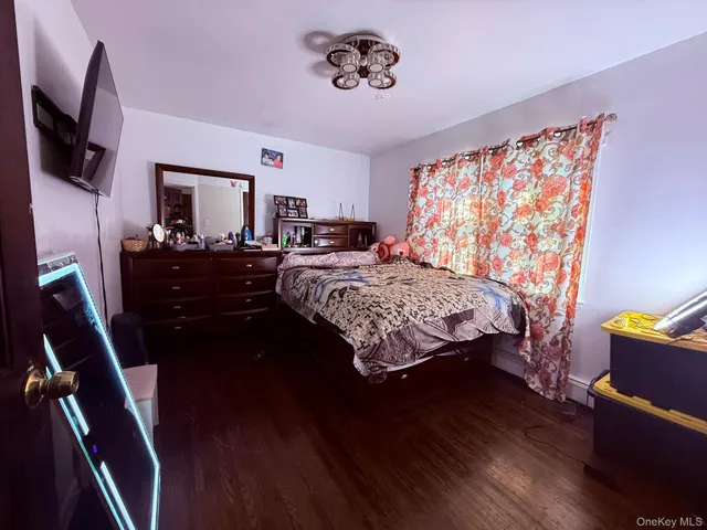 a bedroom with a bed window and a flat screen tv