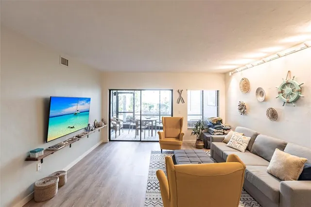a living room with furniture floor to ceiling window and a flat screen tv