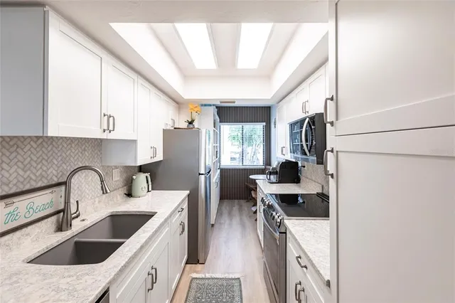 a kitchen with stainless steel appliances granite countertop a sink stove and refrigerator