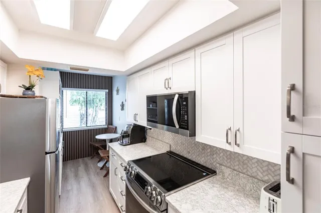 a kitchen with stainless steel appliances a stove a sink refrigerator and a microwave