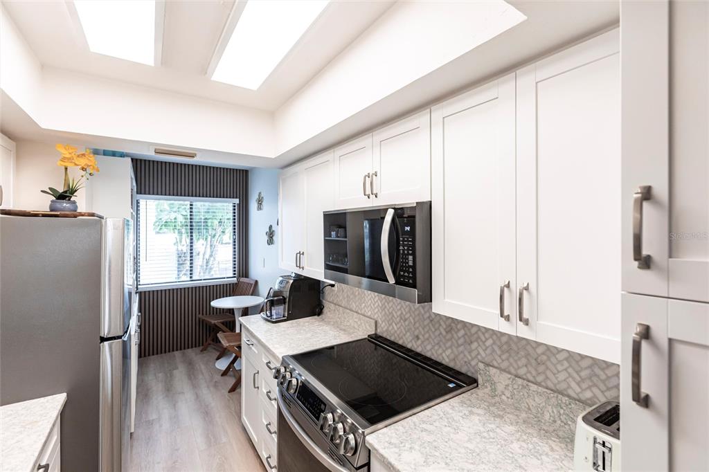 2955 North Beach Road, Unit B612 Englewood, FL 34223 - Photo 9 of 24 a kitchen with stainless steel appliances a stove a sink refrigerator and a microwave