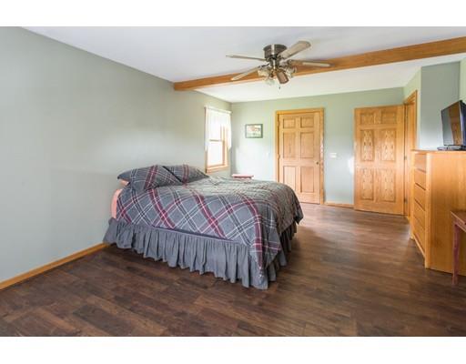 197 Douglas Road Warren, MA 01083 - Photo 14 of 28 a bedroom with a bed and a chandelier