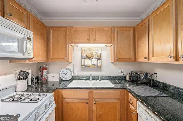 a kitchen with stainless steel appliances granite countertop a sink stove top oven and cabinets