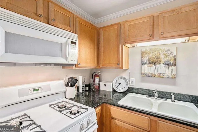 a kitchen with a sink a stove and cabinets