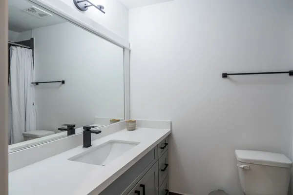 a bathroom with a double vanity sink a mirror and bathtub