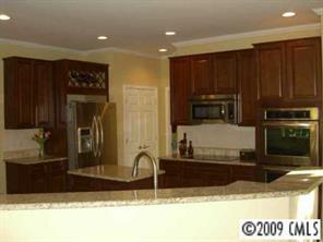 15819 Lavenham Road Huntersville, NC 28078 - Photo 4 of 8 a kitchen with kitchen island granite countertop a refrigerator and a stove top oven