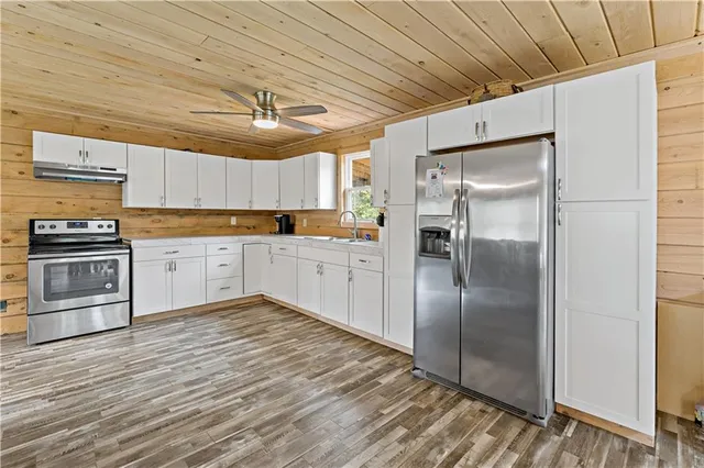 a kitchen with granite countertop a refrigerator and a sink