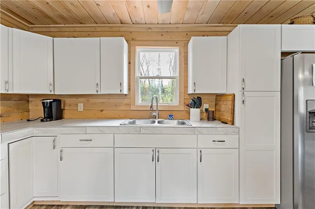 a kitchen with white cabinets and window