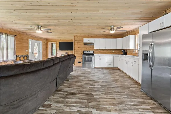 a large kitchen with kitchen island a large counter top space a sink stainless steel appliances and cabinets